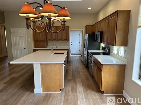 A kitchen with wooden cabinets and a white island.