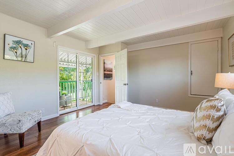 A bedroom with a large bed and a chair.