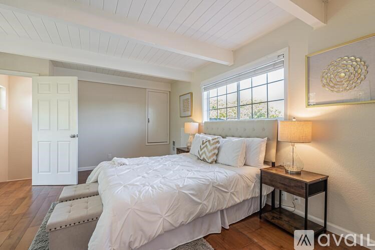 A bedroom with a large bed and a window.