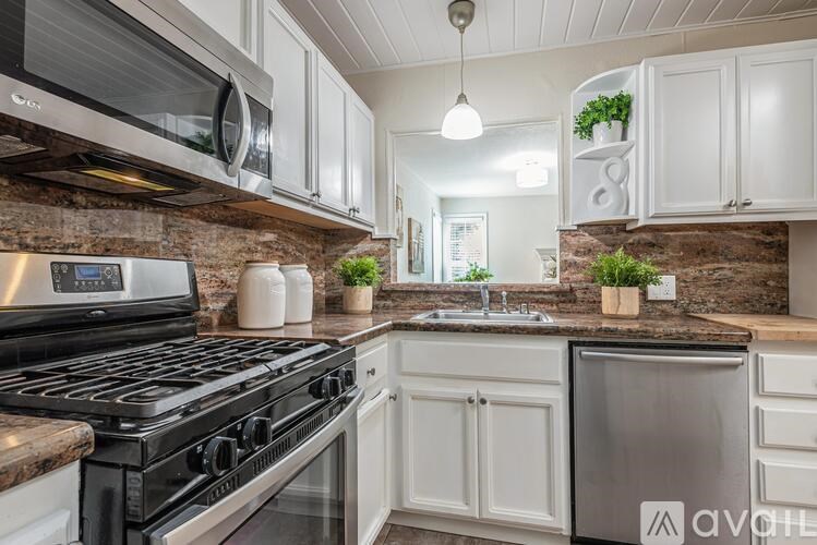 A kitchen with a black stove top oven and white cabinets.