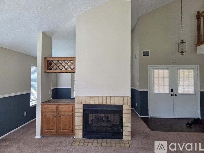 A living room with a fireplace and a cabinet.