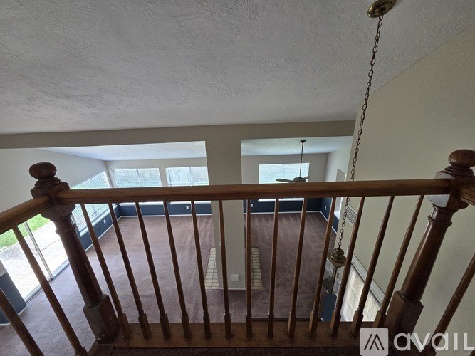 A view from the top of a staircase looking down to a living room.