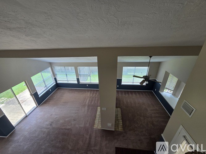 A large open room with a brown floor and a ceiling with exposed beams.