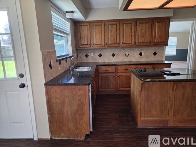 A kitchen with wooden cabinets and a black countertop.