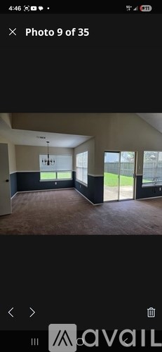 A room with a large window and a door is shown in this photo.