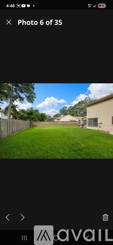 A backyard with a fence and a house in the background.