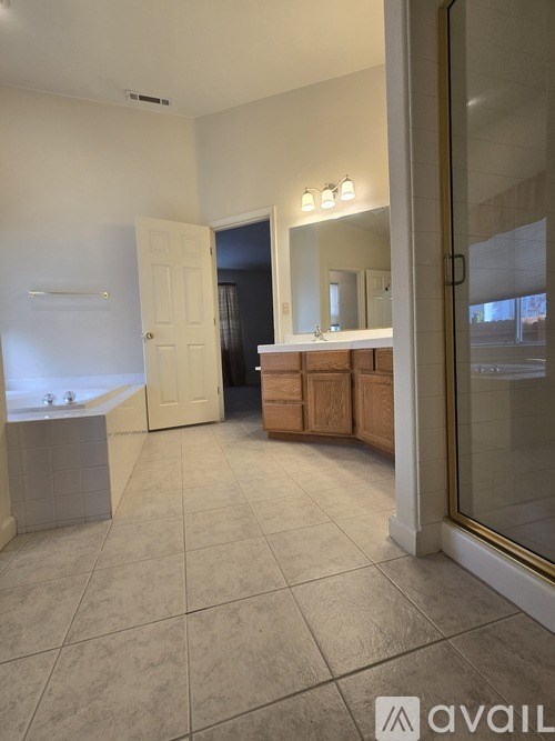 A bathroom with a tub, sink, and mirror.