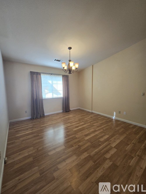 A room with wooden flooring and a chandelier.