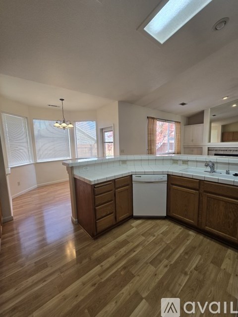 A kitchen with wooden floors and a white dishwasher.