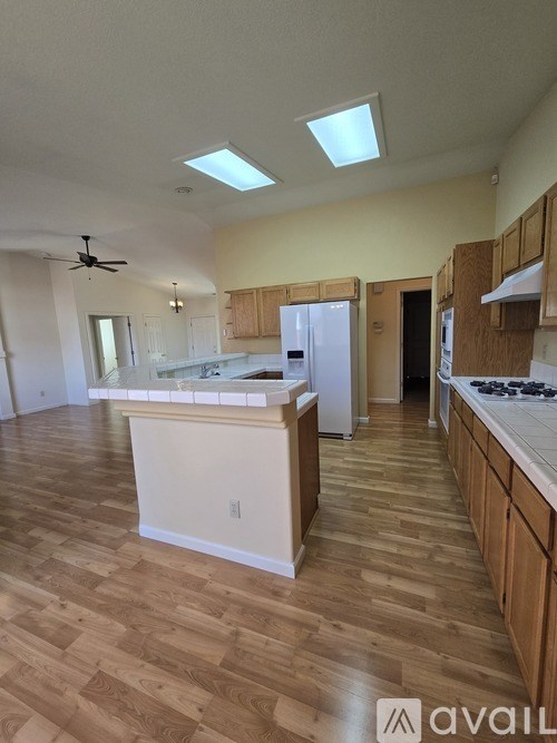 A kitchen with wooden floors and a white island.