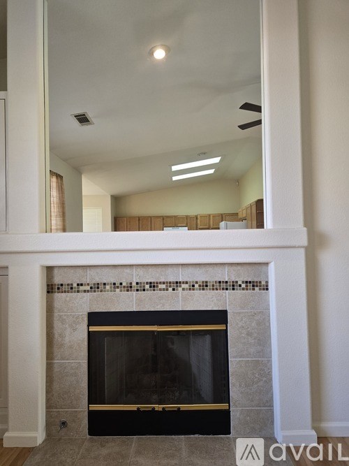 A fireplace with a black grate and a tiled surround.