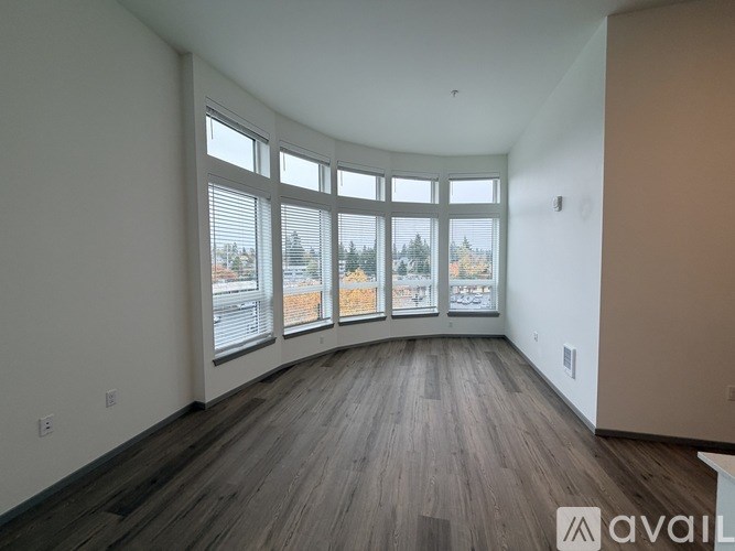 A room with a large window and wooden flooring.
