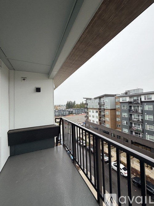 A balcony with a black railing and a small black box on the wall.