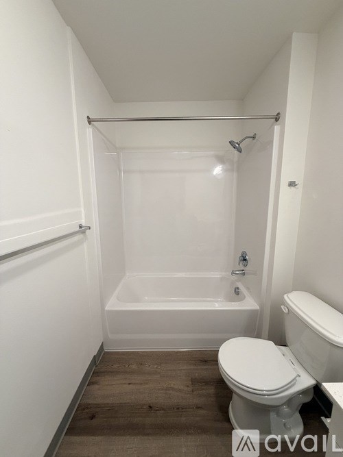 A white bathroom with a toilet, tub, and shower.