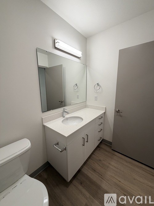 A bathroom with a white toilet, sink, and mirror.