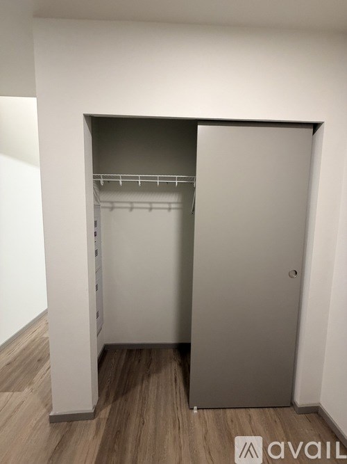 A small closet with a shelf and a door open.