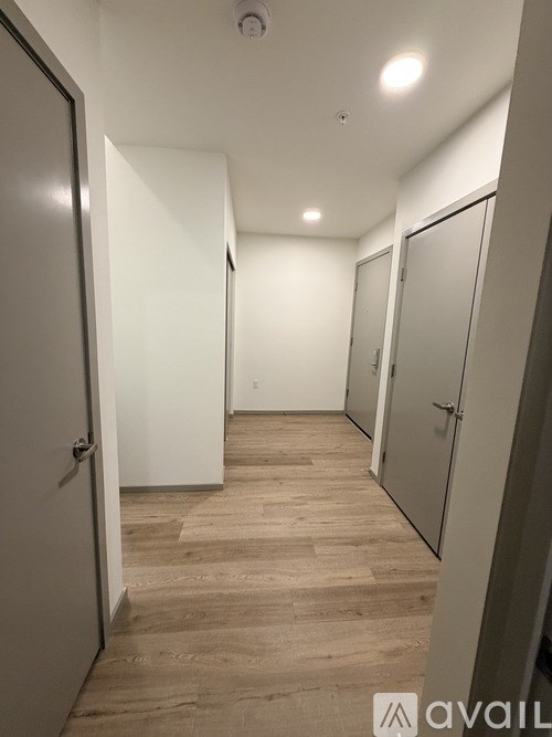 A hallway with white doors and wooden floors.