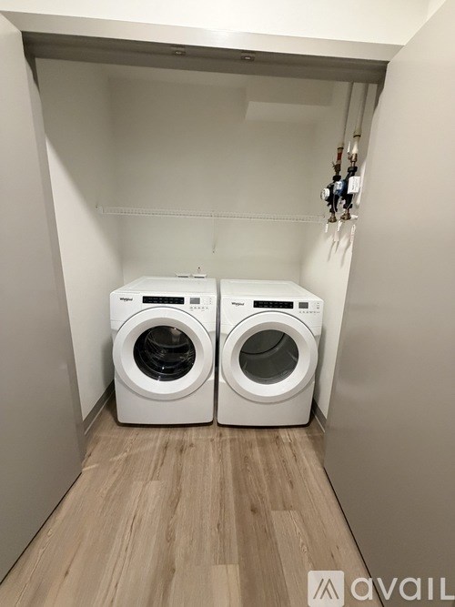 Two front loading washing machines in a small laundry room.
