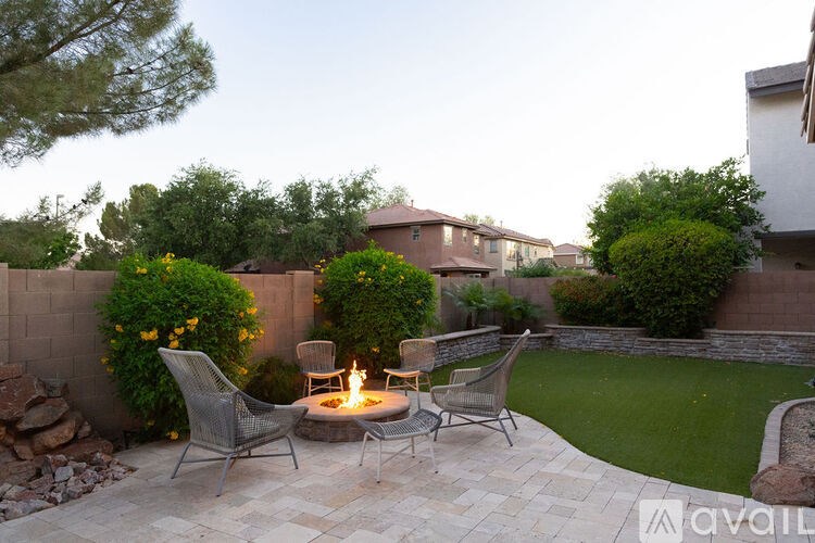 A patio with a fire pit and chairs.