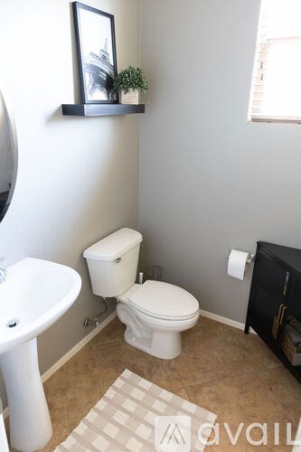 A white toilet sits in a bathroom next to a white sink.