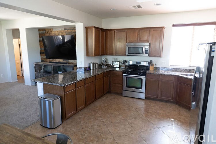 A kitchen with brown cabinets and a granite countertop.