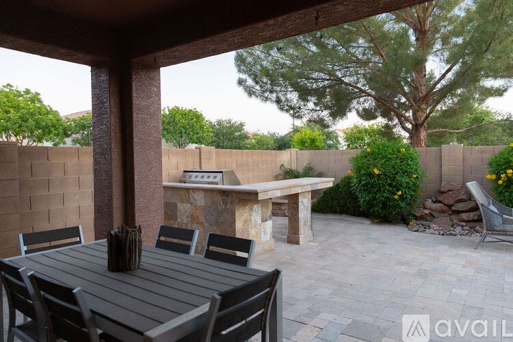 A patio with a table and chairs under a roof.