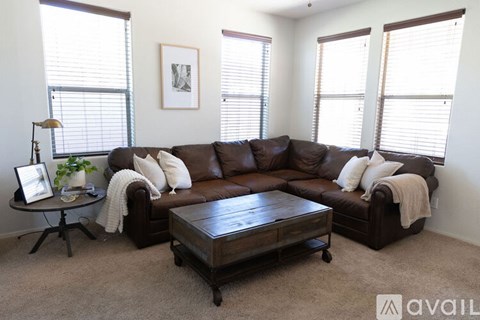 A living room with a brown leather couch and a wooden coffee table.