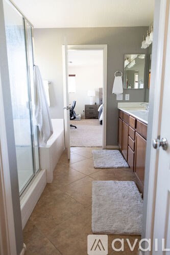 A bathroom with a glass shower door and a white towel hanging on the side.