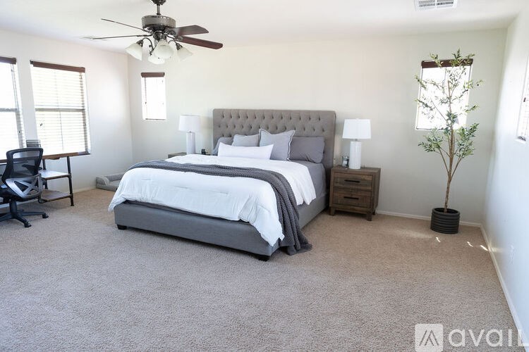 A bedroom with a large bed and a ceiling fan.