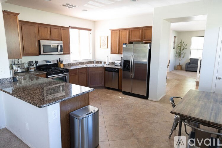 A kitchen with brown cabinets and a granite counter top.