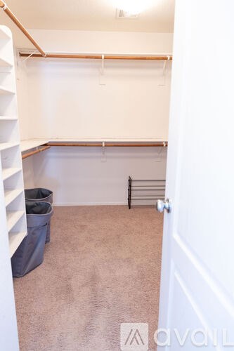 A room with a white door and a grey carpet.