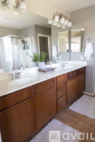 A bathroom with two sinks and a large mirror.