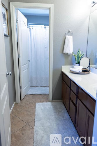 A bathroom with a white shower curtain and a white towel hanging on the wall.