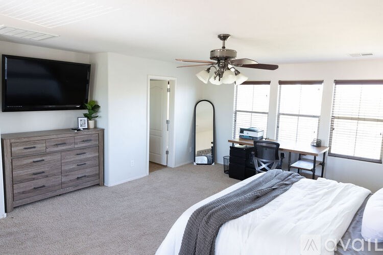 A bedroom with a large bed and a flat screen TV mounted on the wall.