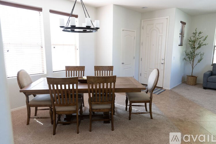 A dining room with a table and chairs.
