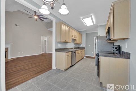 A kitchen with wooden cabinets and a black refrigerator.