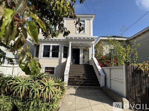 A house with a front yard and stairs leading to the front door.