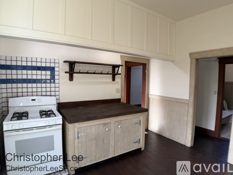 A kitchen with a white stove and wooden cabinets.