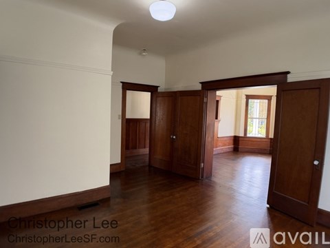 A room with wooden floors and a white ceiling with a light fixture.