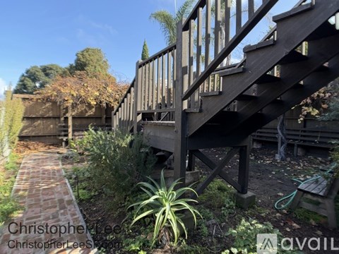 A wooden staircase in a garden with a brick pathway.