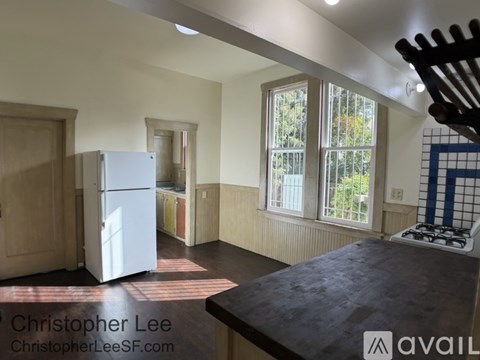 A kitchen with a white fridge and a black counter top.