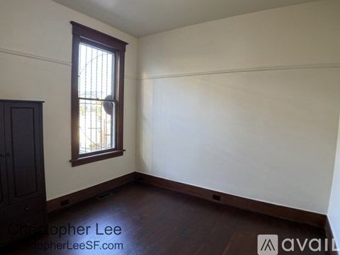 A room with a window and wooden floors is available for rent.