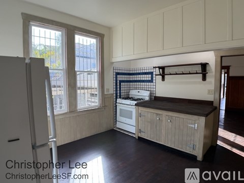 A kitchen with white cabinets and a white refrigerator.