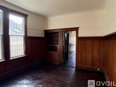 A room with wooden floors and a wooden cabinet with glass doors.