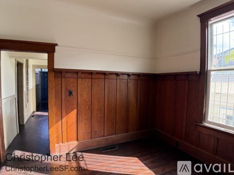 A room with wooden walls and a window showing a cityscape outside.