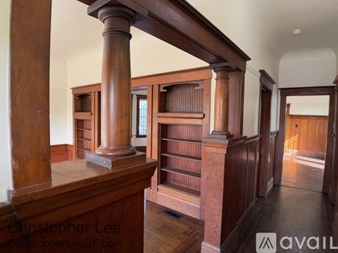 A room with wooden columns and a balcony.