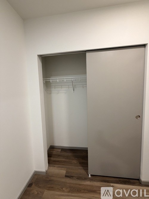 A small closet with a white door and a shelf.