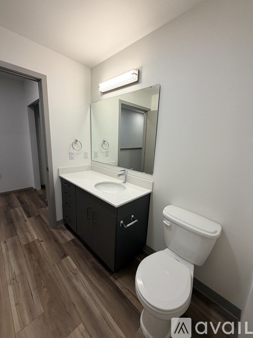 A bathroom with a toilet, sink, and mirror.