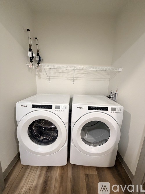 Two front loading washing machines in a small laundry room.