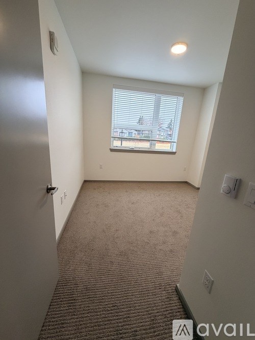 A carpeted hallway with a window overlooking a cityscape.